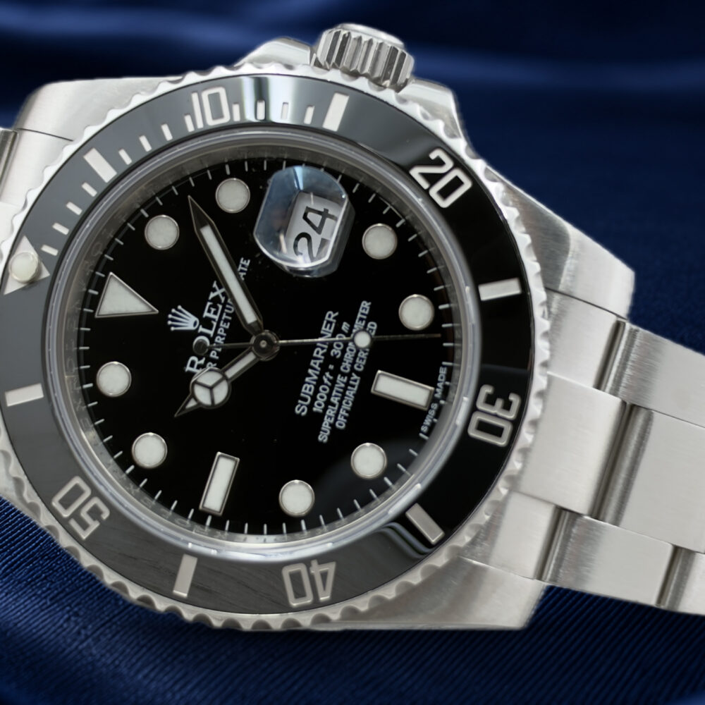 Rolex Submariner Date 116610LN appoggiato sul fianco, con quadrante nero, lunetta nera e bracciale Oyster.