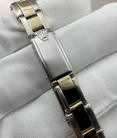 Chiusura del bracciale bicolore del Rolex Oyster Perpetual 6619 appoggiato sul guanto bianco.