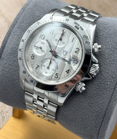 Tudor Prince Date 79280P: vista a tre quarti della cassa, con corona e pulsanti del cronografo sul supporto.